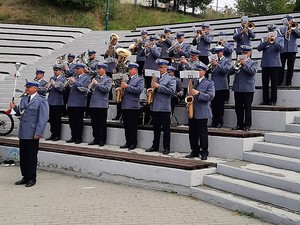 na zdjęciu widać ustawionych na stopniach członków policyjnej orkiestry, policjanci trzymają w rękach instrumenty muzyczne