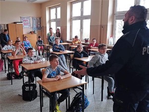 policjant prowadzi spotkanie profilaktyczne z uczniami szkoły podstawowej