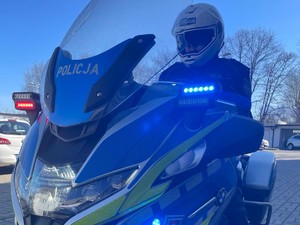 policjant siedzi na policyjnym motocyklu